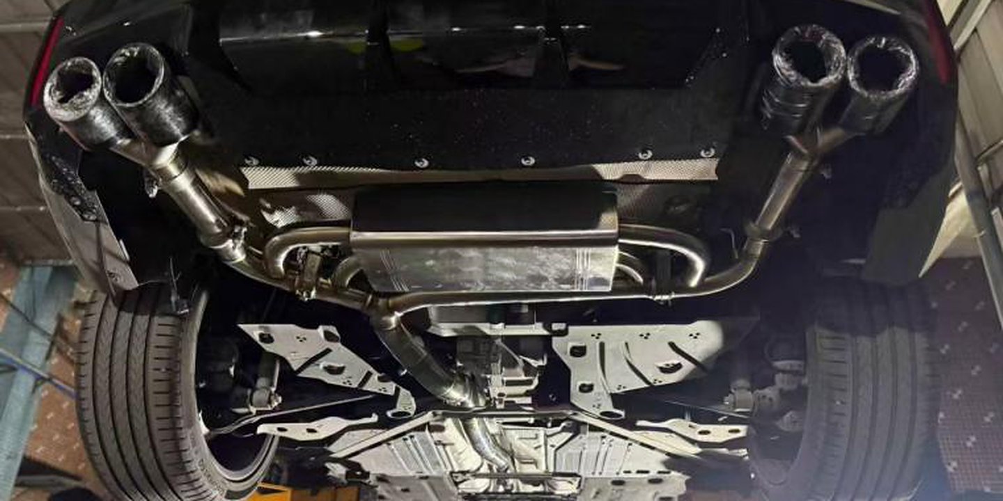BMW M car on a lift, seen from behind: the quad tips and rear section fitted